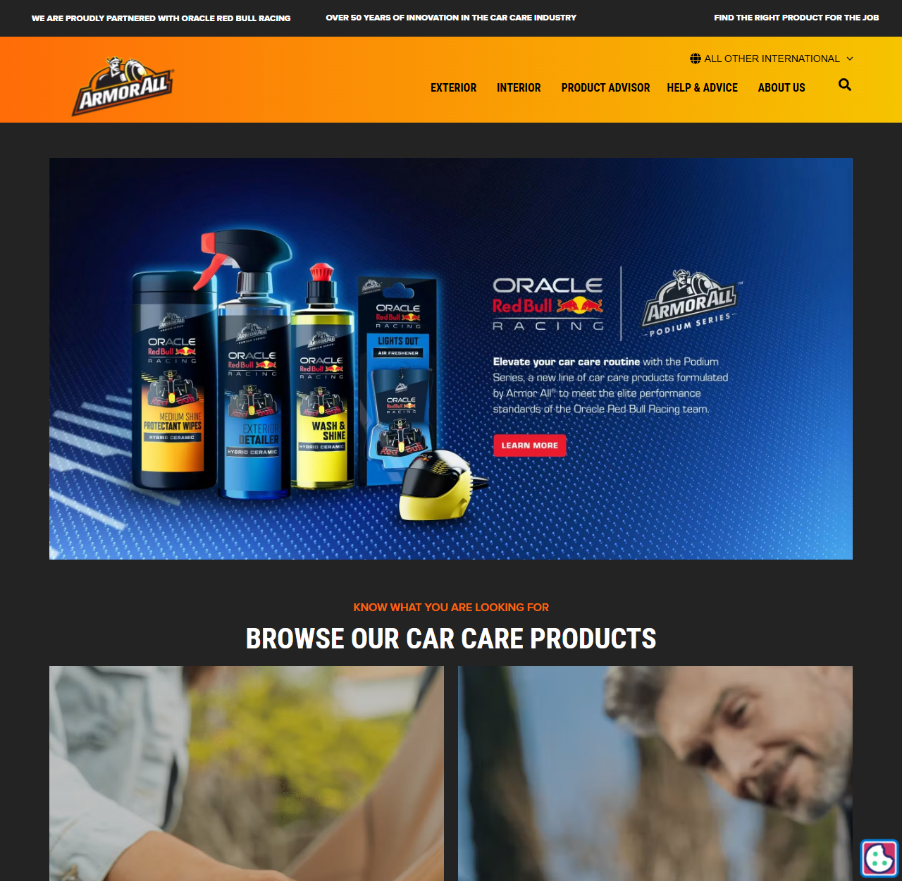 Armor All本国のブランドサイトのトップページ。オレンジ色のロゴと、Oracle Red Bull RacingとArmor All Podium Seriesのロゴが入った青い広告画像があり、ミディアムシャインプロテクタントワイプス、エクステリアディテーラー、ウォッシュ＆シャインなどのボトルが並んでいる。上部にはOracle Red Bull Racingとの提携と、カーケア業界で50年以上の革新というメッセージが表示されている